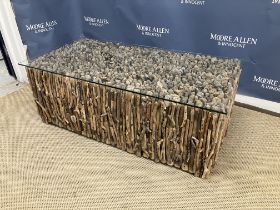 A modern glass top rectangular coffee table on driftwood decorated base,