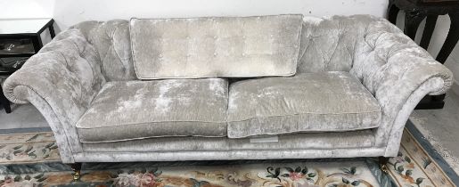A modern silvered velvet style upholstered buttoned scroll arm sofa on turned mahogany front legs