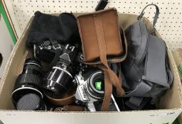 A box of assorted camera equipment to include two Nikon cameras, a Praktica IV F camera,