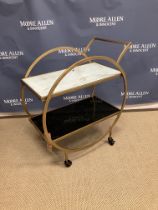 A modern gold painted metal framed two tier tea trolley of circular form in the Art Deco taste,