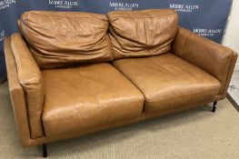 A modern mid brown leather upholstered two seat sofa on tubular metal framed legs 167 cm wide x 94