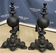 A large pair of cast iron andirons with column capped sphere and crowned figural bust with bare