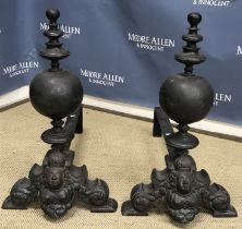 A large pair of cast iron andirons with column capped sphere and crowned figural bust with bare