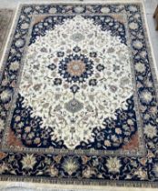 A large Indo-Persian wool carpet, the cream ground with central red brick and floral medallion,