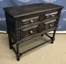 A 1930s oak chest of two long drawers in the Jacobean manner raised on barley twist supports united