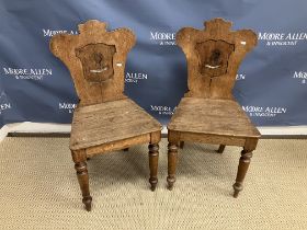 A pair of Victorian oak panel seated hall chairs with painted armorial backs inscribed "Nil nisi