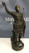 A patinated bronze figure of Caesar Augustus with Cupid at his heel on a circular base 35 cm high