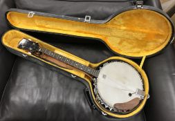 A Hondo four string banjo with Remo Weatherking banjo head, 88 cm long, housed in a hard case,