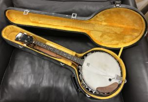 A Hondo four string banjo with Remo Weatherking banjo head, 88 cm long, housed in a hard case,