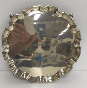 A silver salver with a pie crust rim raised on three feet inscribed "1947 Iris 1953" (by Selfridge