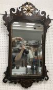 A walnut fretwork carved wall mirror with hoho bird finial in the 18th Century manner 52 cm wide x