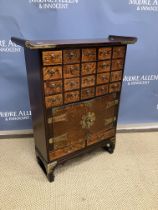 A modern Oriental elm dwarf side cabinet with bank of twenty drawers of two cupboard doors and two