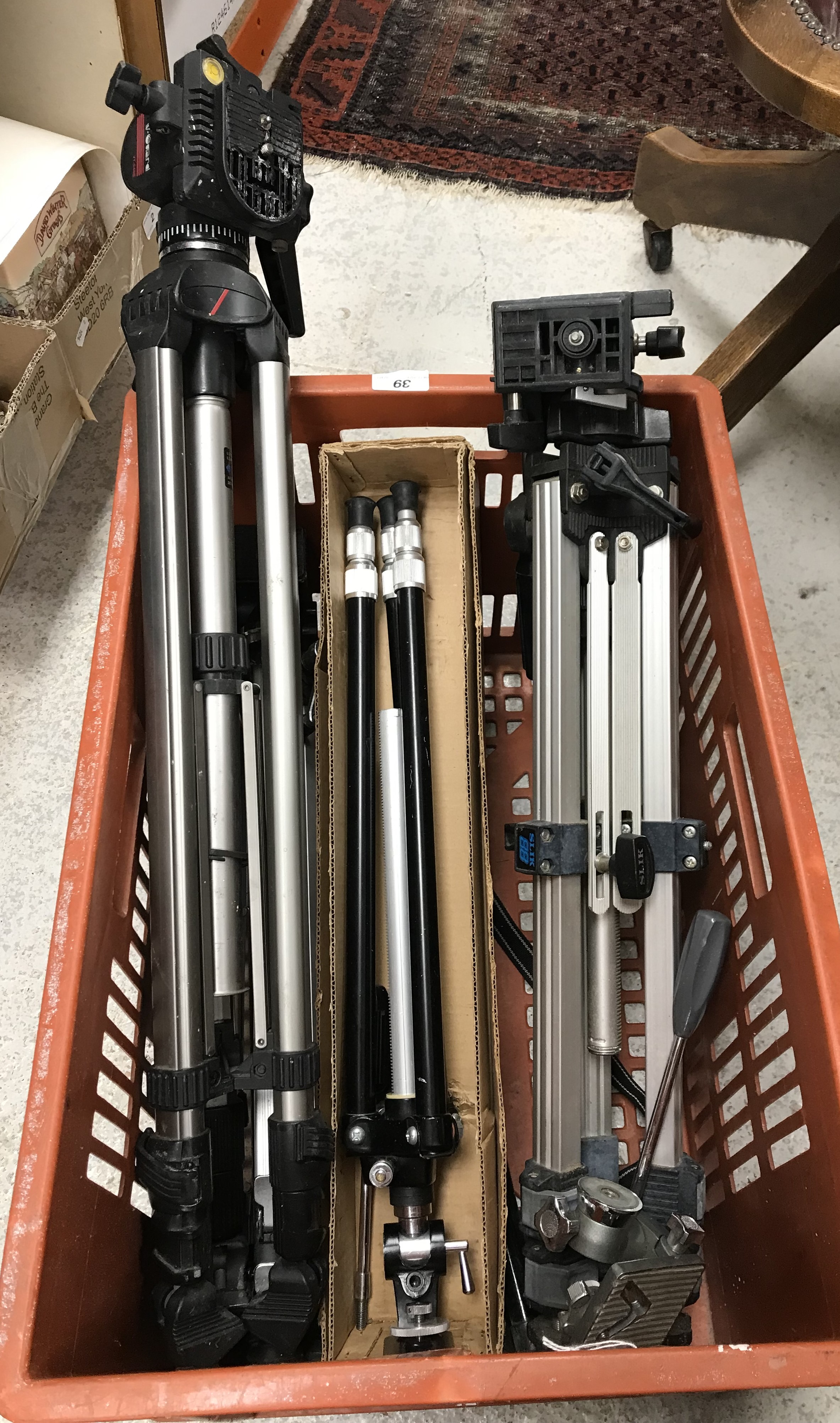 A crate containing various camera tripods