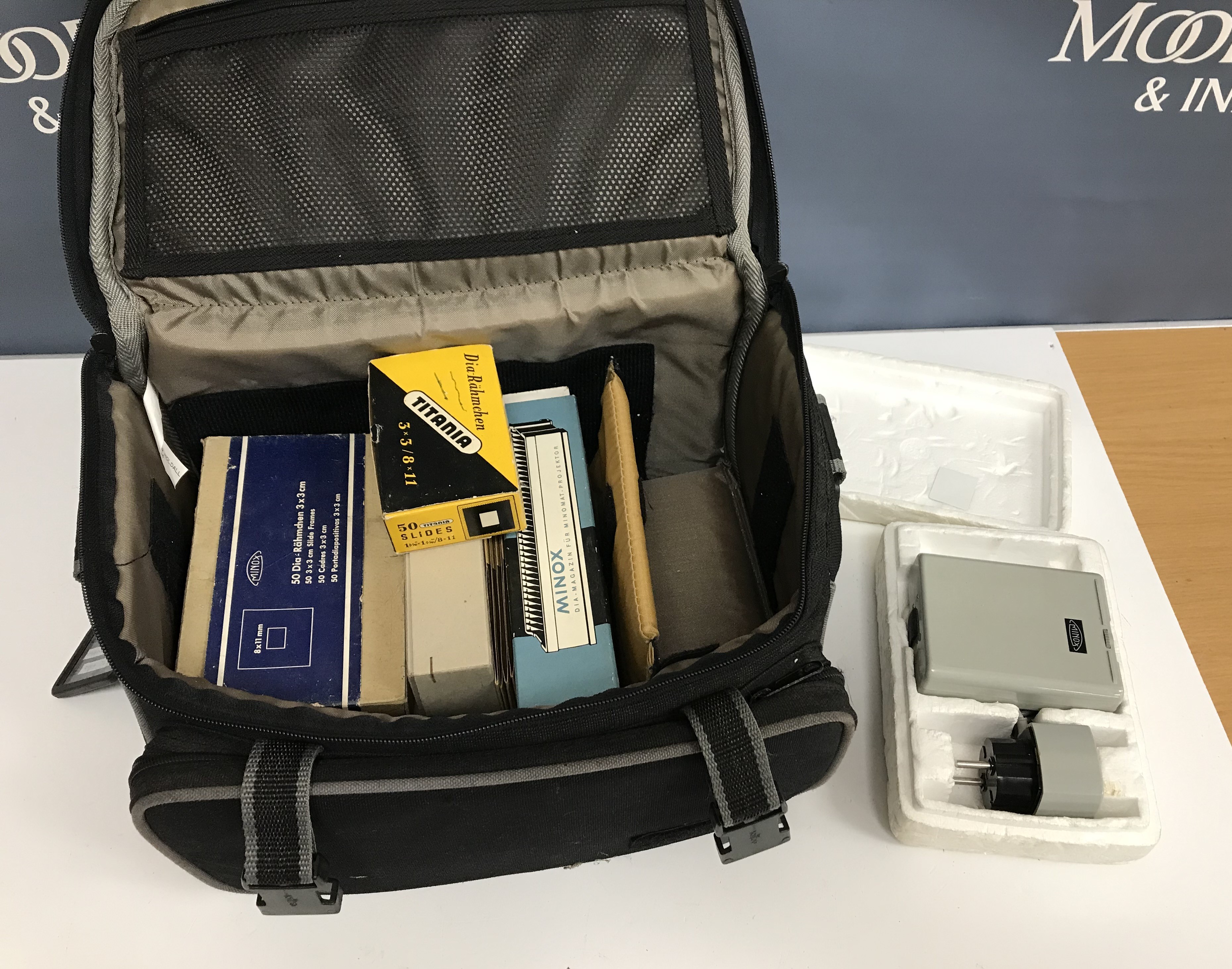 A camera bag containing Minox camera accessories including slide holder and slide frames tc