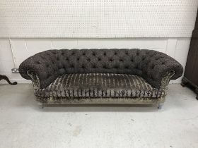 A modern buttoned upholstered Chesterfield sofa on silvered turned and reeded front legs,