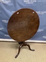 A late George III oak tea table the circular snap top on a turned pedestal to cabriole tripod base