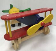 A collection of child's wooden painted ride on toys comprising a bi-plane, boat,