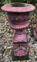 A painted composite stone urn of campana form on a pedestal base,