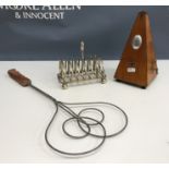 A box containing a collection of items to include a metronome, plated six section toast rack,