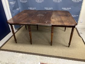 An early 19th Century mahogany rounded rectangular extending dining table on slender turned and