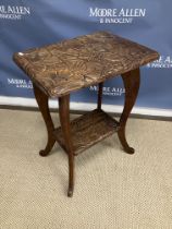 A Liberty carved teak rectangular two tier occasional table with floral and foliate decoration