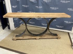 A modern hall table, the pine plank top on a polished steel medallion support and pine plank base,