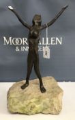 A Modernist style bronze of a nude woman with arms raised upon a rock base 38 cm high