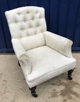 A Victorian buttoned upholstered scroll arm chair on turned mahogany front legs to castors and a