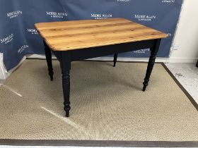 A Victorian pine farmhouse style kitchen table the later top above an end drawer on black painted