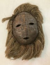 A Tores Straits Papua New Guinea turtle shell mask with punched decoration and coconut fibre hair,