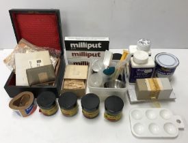 A box of various ceramic restoration items including Milliput ceramic glaze, bronze powder,