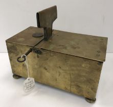 A 19th Century brass "honesty" box of rectangular form with coin slot top, raised on squat bun feet,