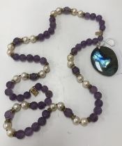 A Chinese pearl and carved amethyst court type bead necklace with 9 carat gold mounts/clasp 40 cm