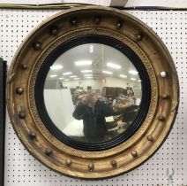 An early 19th Century gilt framed circular convex mirror with ball decoration 58 cm diameter