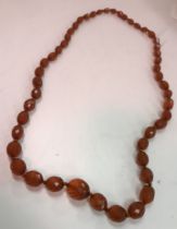 A vintage graduated single row of faceted cut amber beads necklace, 77 cm long,