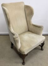 A George III mahogany framed wing back scroll arm chair on carved cabriole front legs to pad feet,