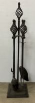 A wrought iron companion set with twisted open finials 89 cm high