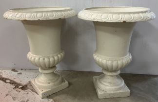 A pair of cast iron painted urns of typical form raised on a square base 47 cm high x 36 cm