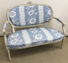 A circa 1900 cream painted framed and carved two seat salon sofa in the Louis XVI taste with