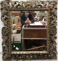 A Regency Florentine giltwood and gesso wall mirror with acanthus leaf mask and shell decoration