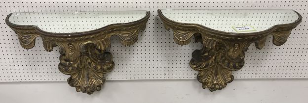 A pair of 19th Century Continental carved giltwood and gesso mirror top wall brackets in the Rococo