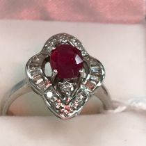 An 18 carat white gold mounted diamond and ruby dress ring, the centre stone approx 0.