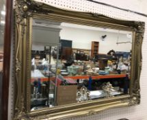 A modern gilt swept framed wall mirror w