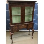 A walnut cabinet on stand in the early 1