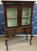 A walnut cabinet on stand in the early 1