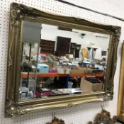 A modern gilt swept framed wall mirror w