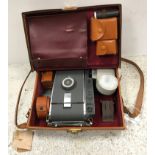 A Polaroid 10A camera in leather satchel