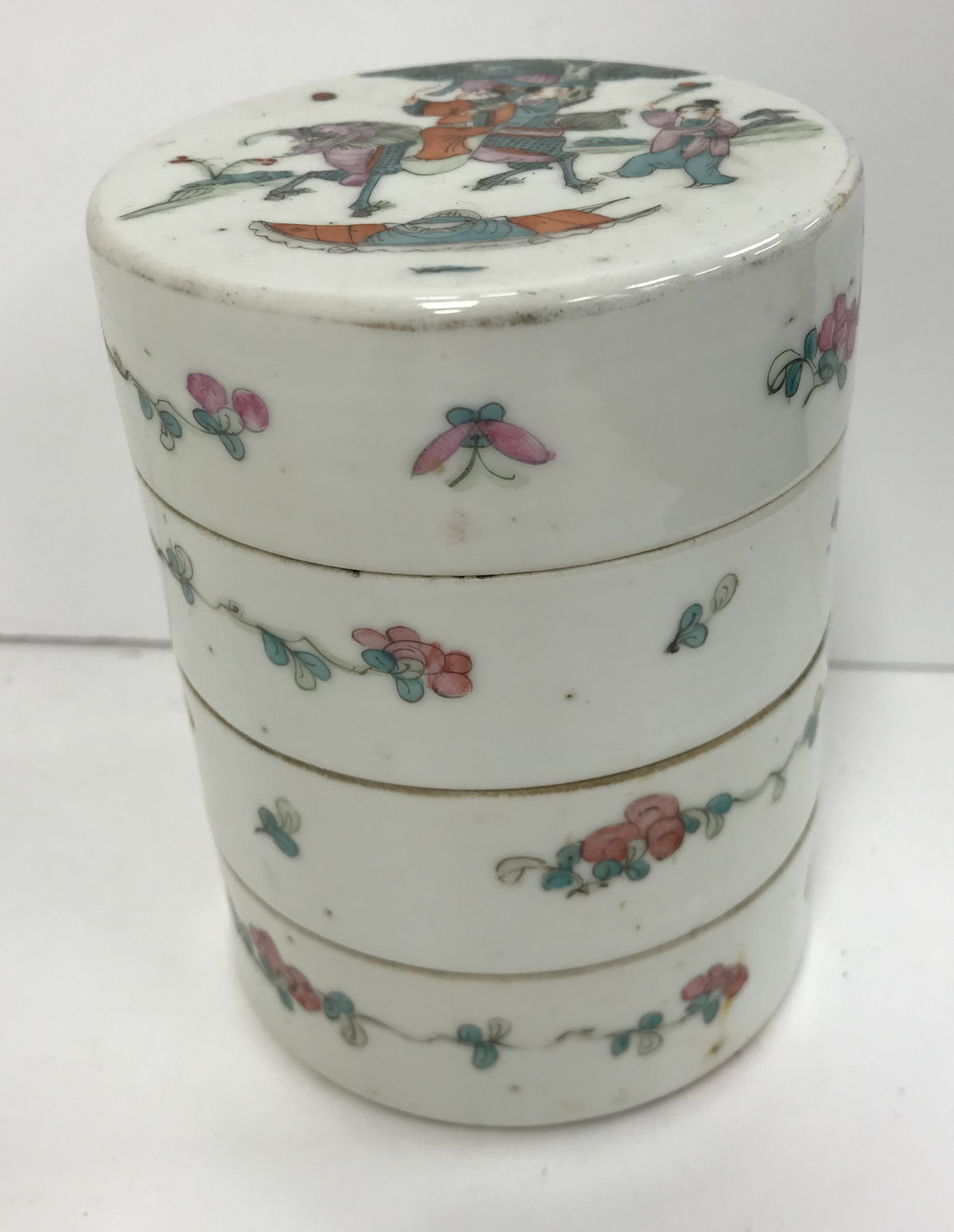 A circa 1900 Chinese porcelain stacking box of four sections in cylindrical form, the top