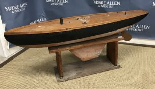 A vintage painted wood pond yacht with metal rudder and keel on a pine stand, 122 cm wide x 30 cm