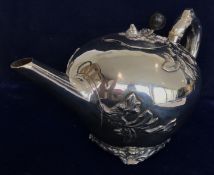 A George V silver teapot in the Chinese taste with relief foliate decoration and branch handle